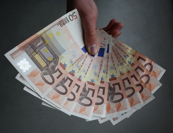 Imagen que muestra a alguien recibiendo dinero en efectivo.